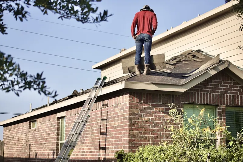 Professional roofer working on a residential roof in Ashley Manor